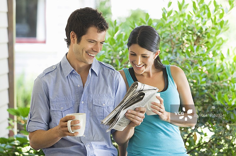 手拿咖啡杯看文件的男女图片素材