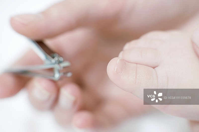 母亲给孩子剪指甲图片素材