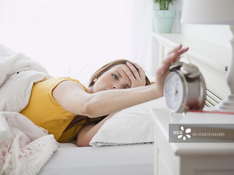 年轻女子关闭闹钟图片素材