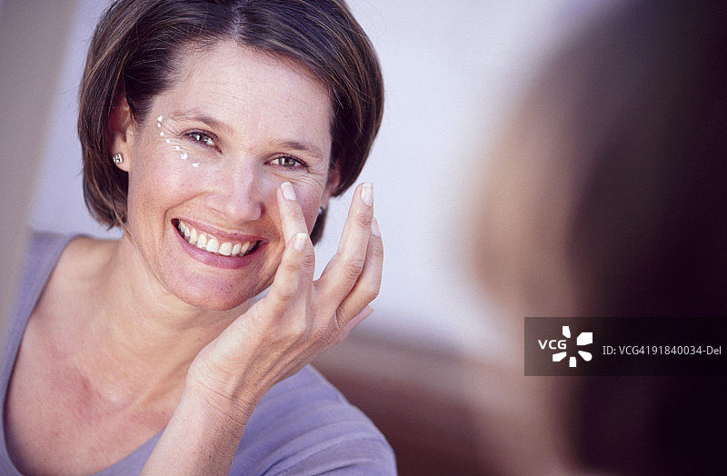 女子涂抹乳液图片素材