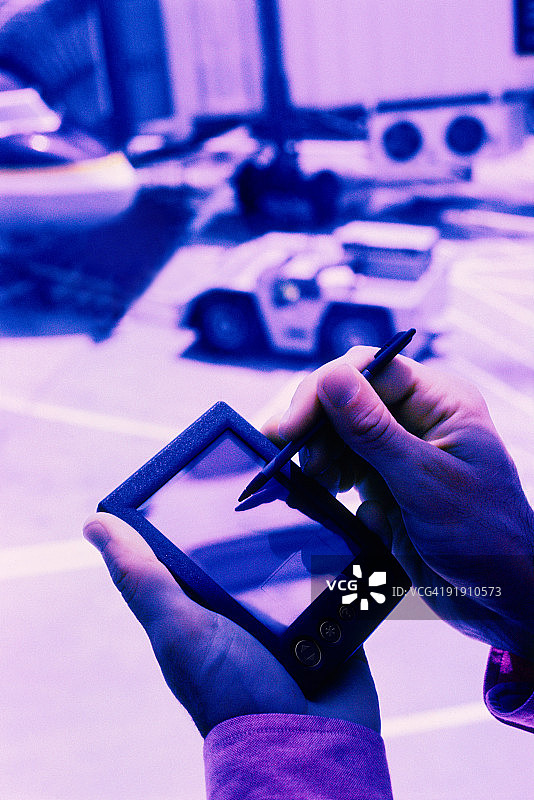 手持掌上电脑，窗外可见飞机图片素材