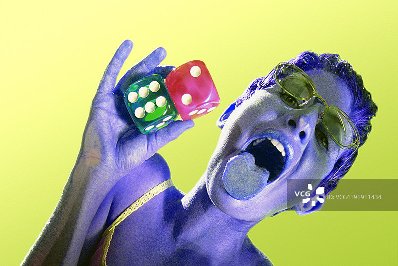 女人躺在塑料上仰视，手持骰子吐舌特写图片素材