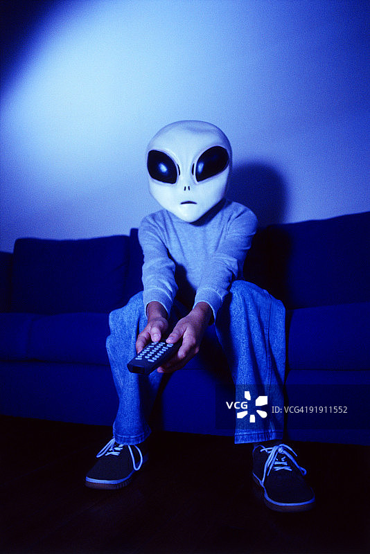 外星儿童在沙发上玩游戏图片素材