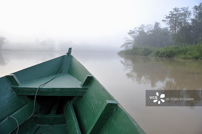 清晨朦胧的京那巴当岸河上的木船图片素材
