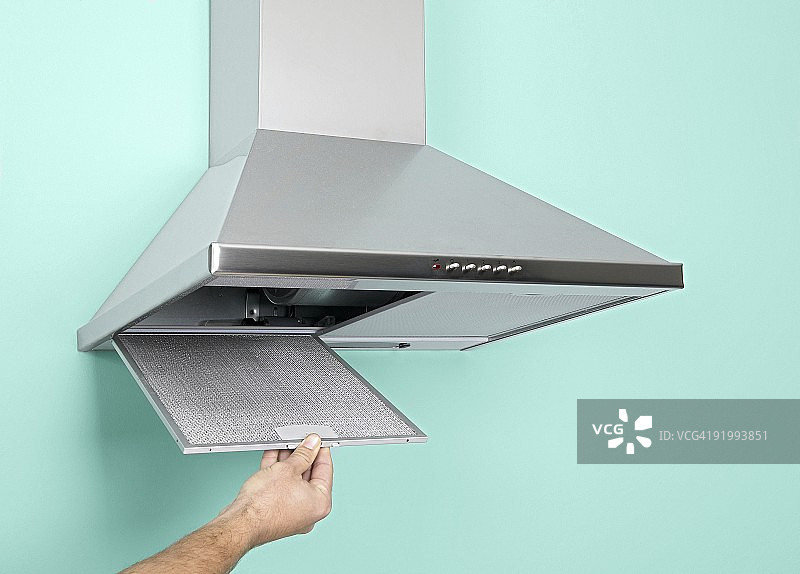 手打开不锈钢炉灶抽油烟机特写图片素材