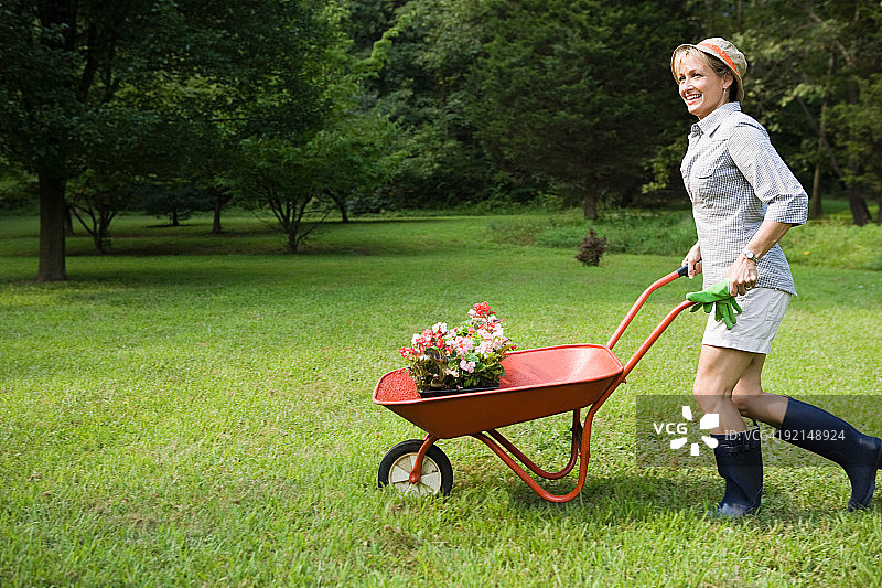 推着装满植物的手推车的女人图片素材