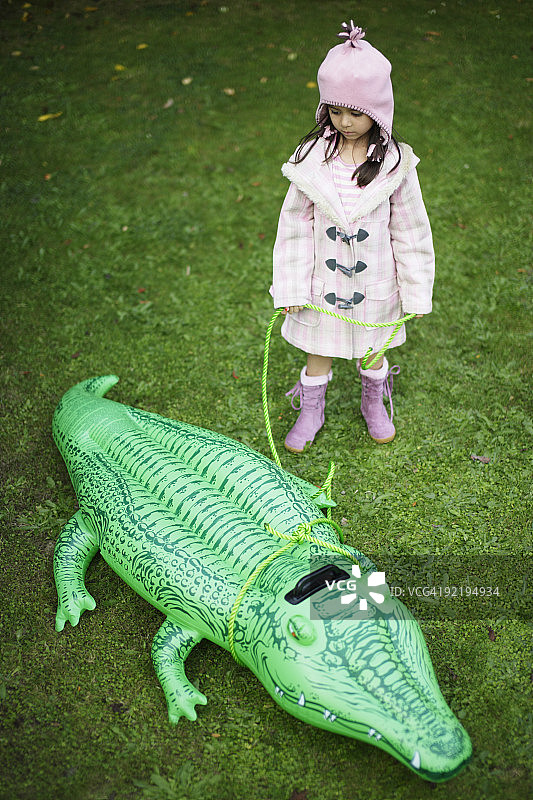 牵着玩具鳄鱼的女孩图片素材