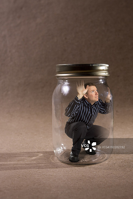 男子被困在玻璃罐里（概念系列）图片素材