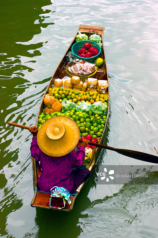 女士在泰国水上市场从她的船上卖水果图片素材