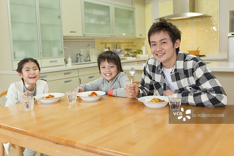 父亲和孩子们吃咖喱饭图片素材