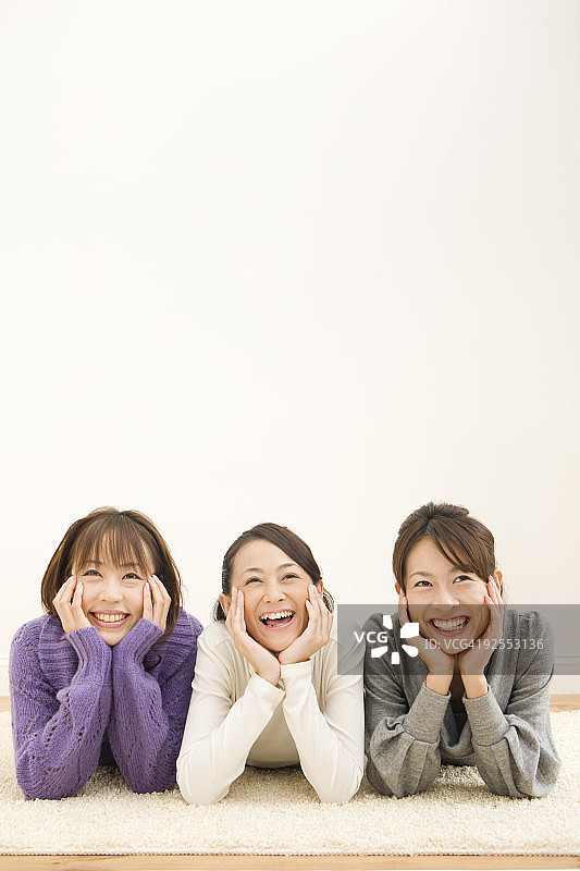 三个年轻女人躺在地板上图片素材