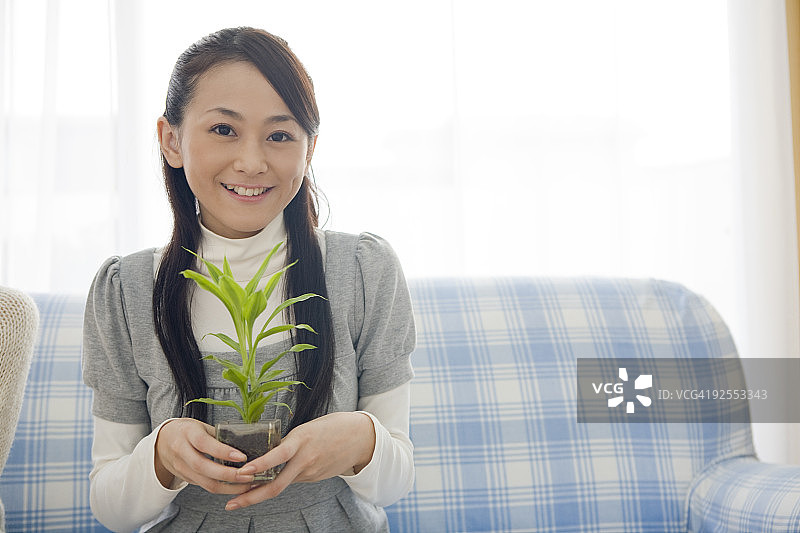 年轻女人手捧盆栽图片素材