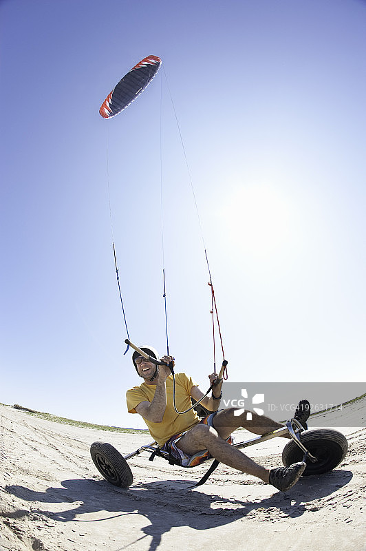 男子在海滩上驾驶风筝车图片素材