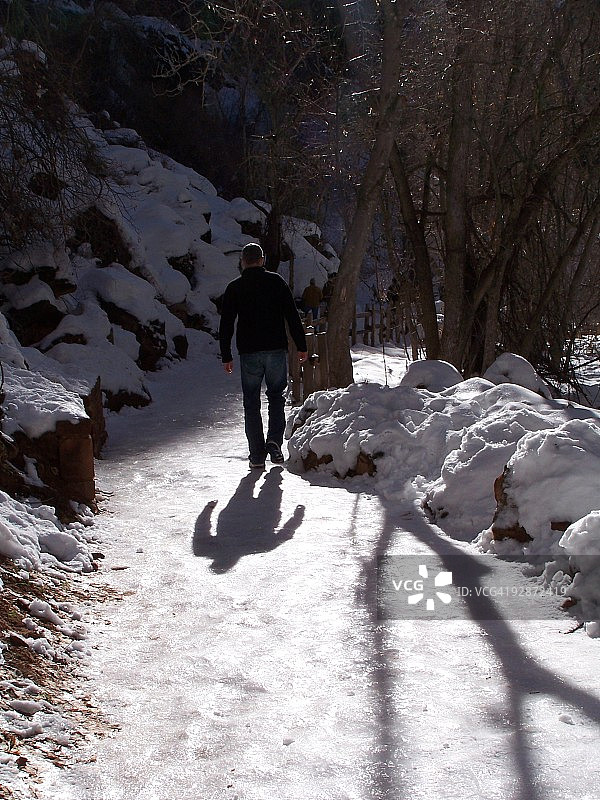 男人在雪路上行走图片素材