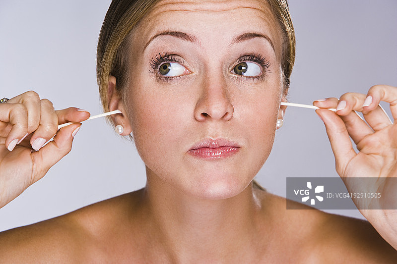 女人用棉签堵住耳朵图片素材