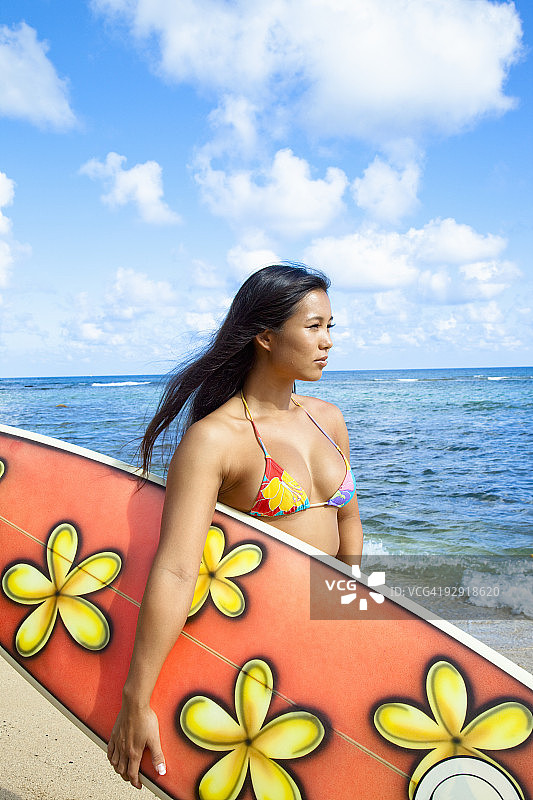 女子手持冲浪板眺望大海图片素材