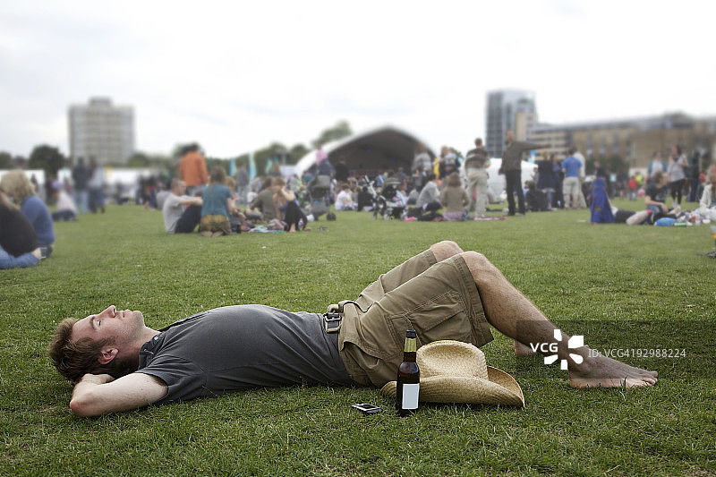 男人躺在草地上参加节日活动图片素材