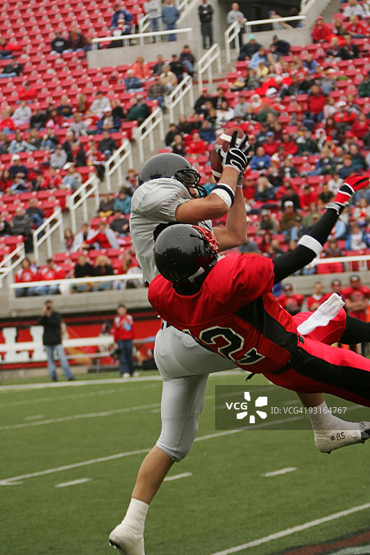 橄榄球运动员在体育场高压下接球图片素材