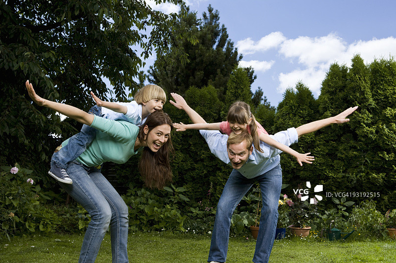 父亲、母亲和他们的儿子女儿一起假装是飞机图片素材