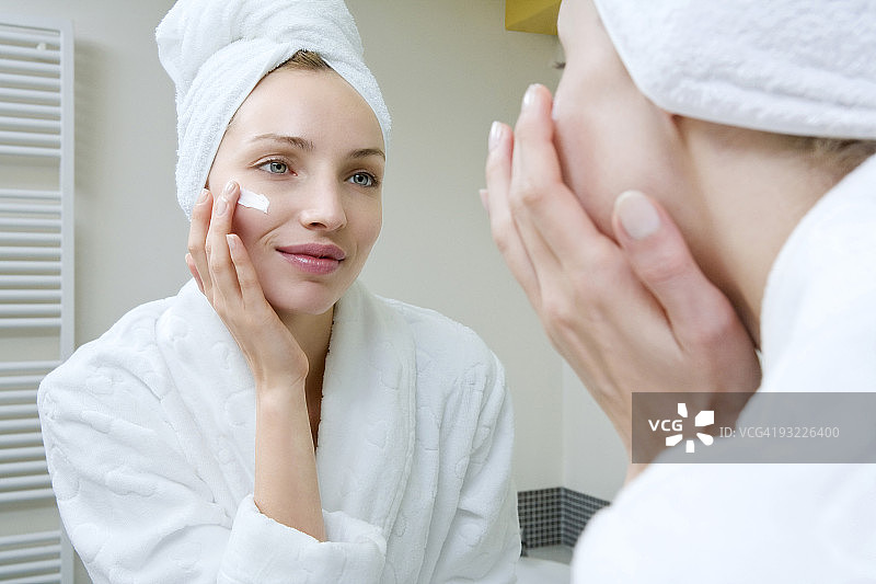 年轻女人涂抹美容霜图片素材