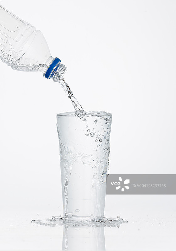 将水从瓶子倒入玻璃杯中图片素材