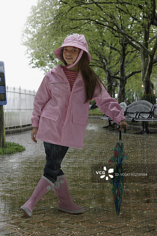 在雨中公园穿着雨具的西班牙裔女孩图片素材