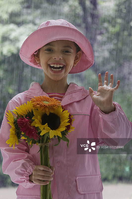 在雨中挥舞鲜花的西班牙裔女孩图片素材