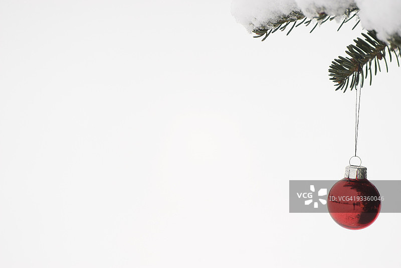 悬挂在积雪树枝上的圣诞节装饰品图片素材