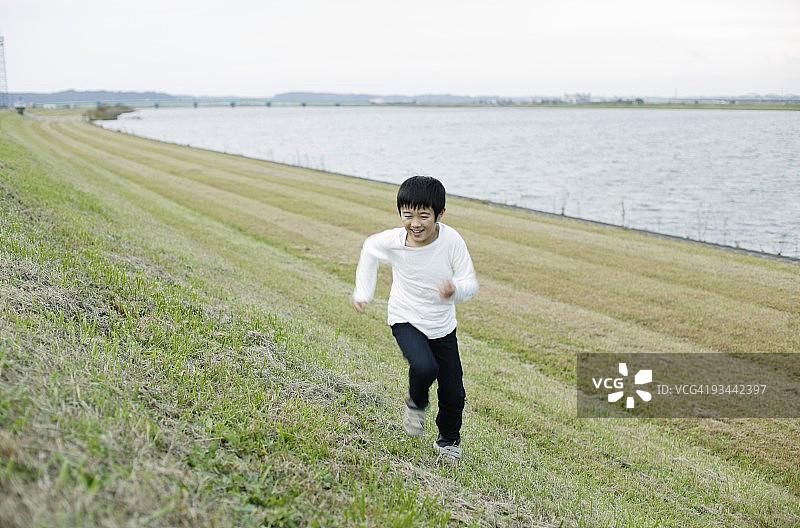 黄昏时男孩在田野奔跑图片素材