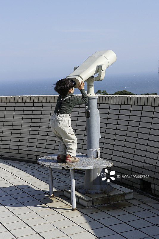 用双筒望远镜观察的男婴图片素材