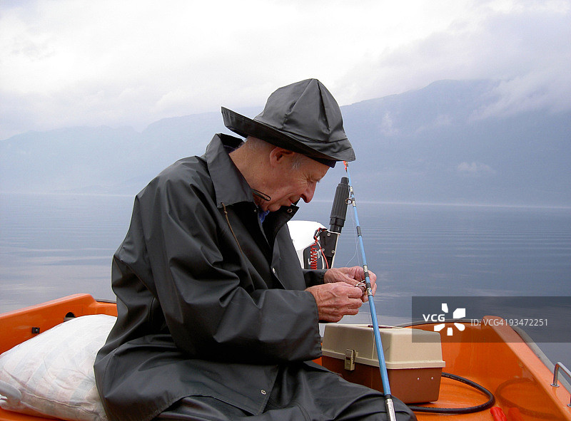 在挪威峡湾清晨诱饵捕鱼的渔夫图片素材