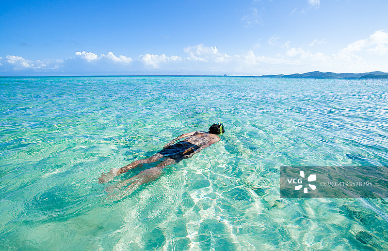 在冲绳清澈的蓝色热带水域浮潜图片素材