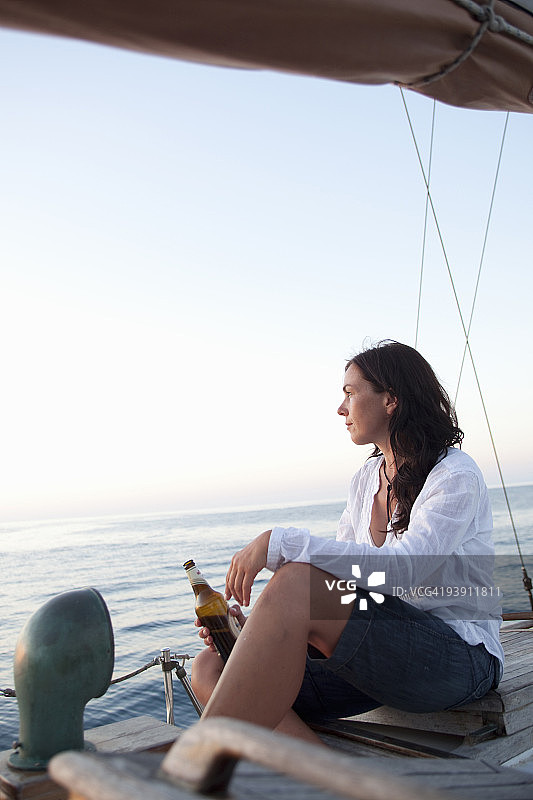 女人喝着啤酒看日落图片素材