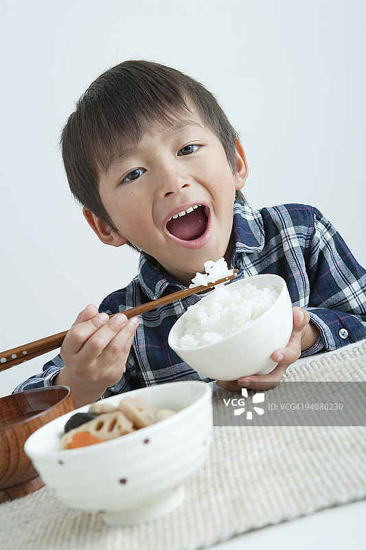 男孩用筷子吃米饭图片素材