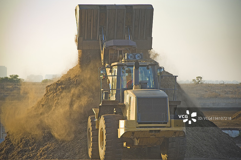 大型装载机堆积覆盖物，地面木屑图片素材