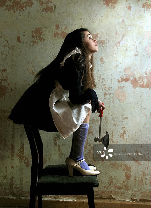 坐在椅子上拿着斧头的女人，卢甘斯克，乌克兰图片素材