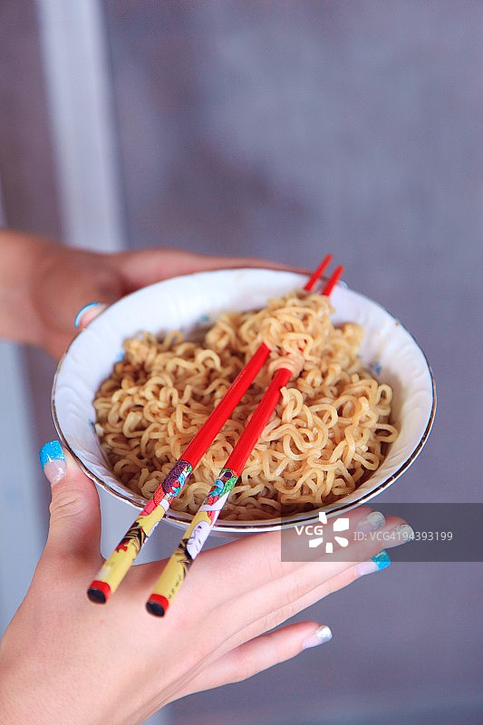 拿着方便面和筷子的女孩图片素材