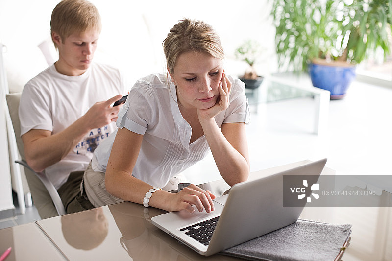 女孩坐在男孩的腿上使用电脑图片素材