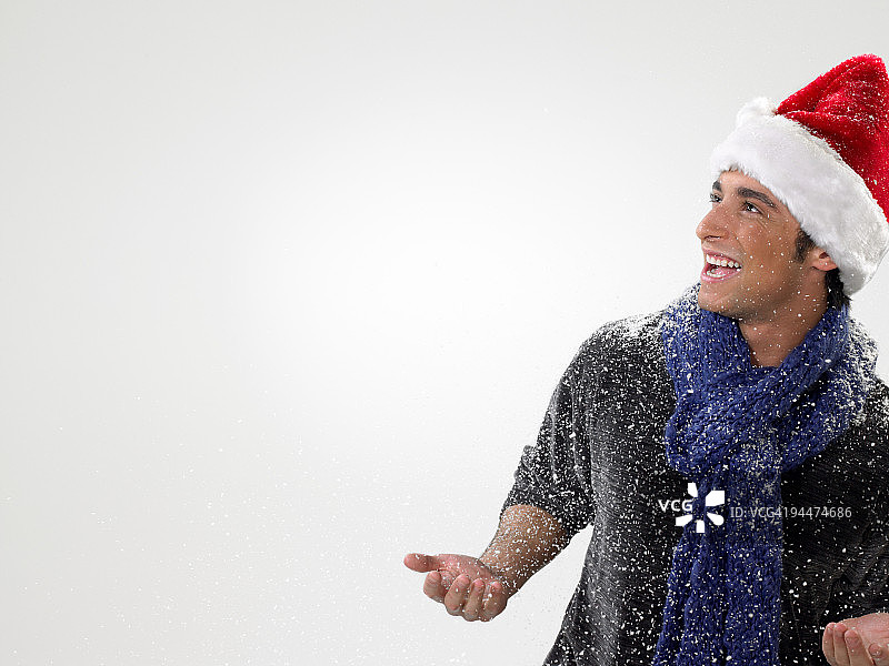 戴着圣诞帽的年轻男人在雪地里图片素材