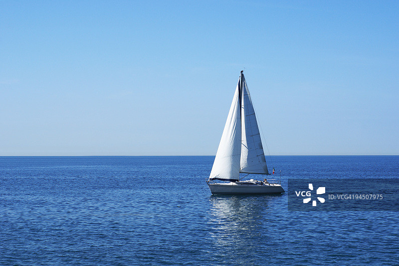 蓝色平静水域上的帆船图片素材