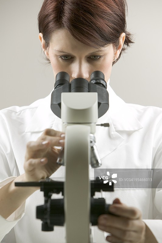 女人正在用显微镜观察图片素材
