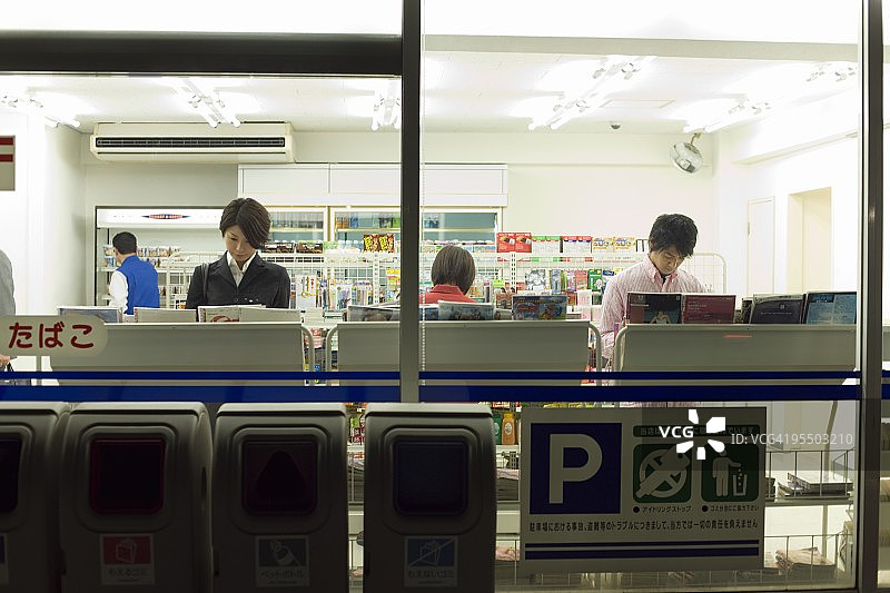 人们在便利店阅读杂志图片素材