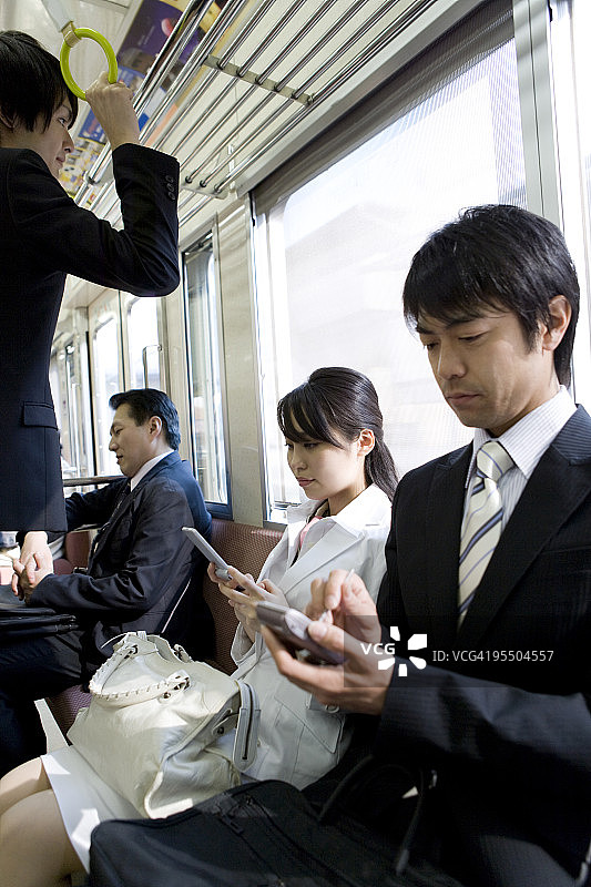 在火车座位上使用PDA的商人图片素材