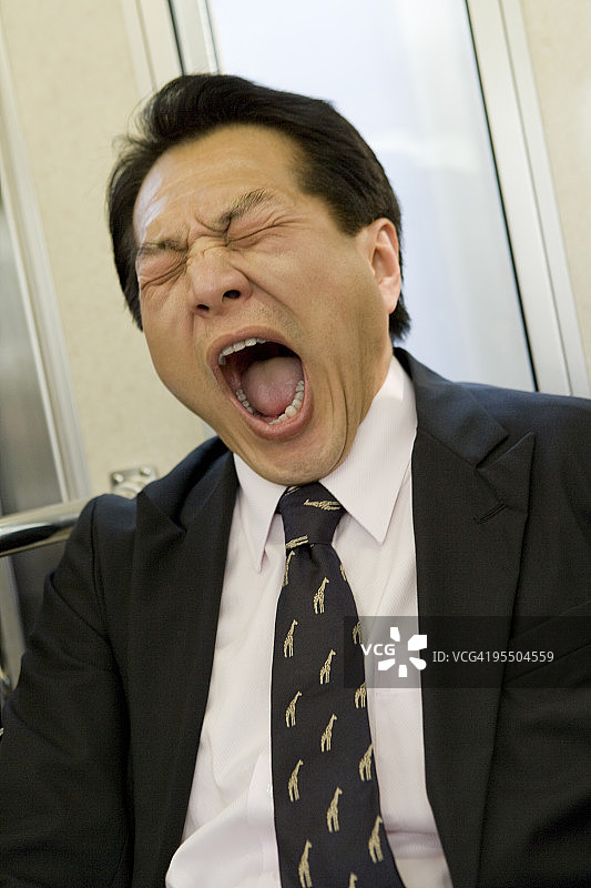 在火车上打哈欠的商人图片素材