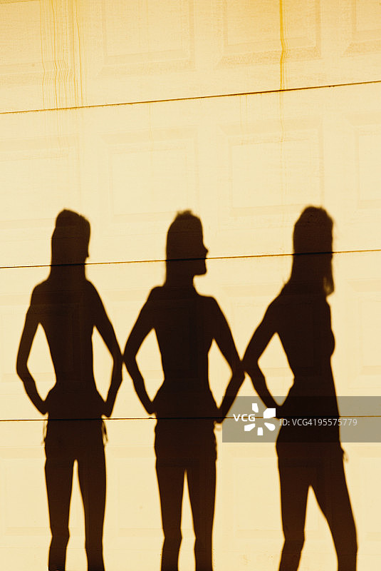 三名女性在墙上形成剪影图片素材