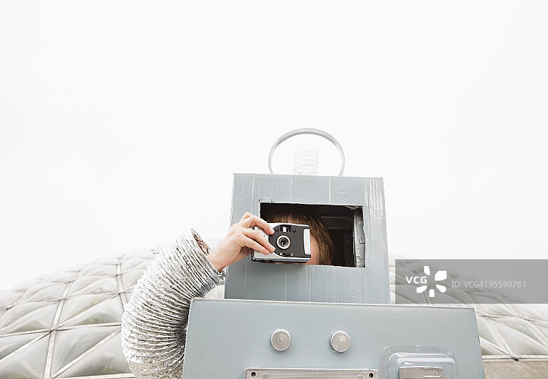 穿着机器人服装的孩子站在生态圈前图片素材