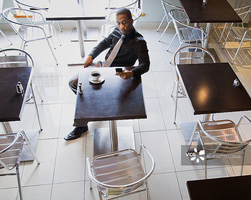 行政人员在咖啡馆阅读PDA上的信息图片素材