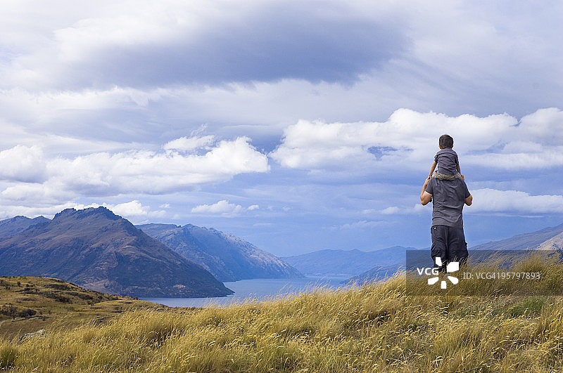 男孩坐在父亲的肩膀上图片素材