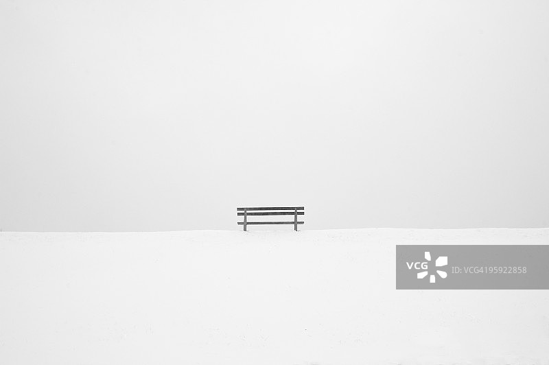 灰色天空下雪山上的长椅图片素材