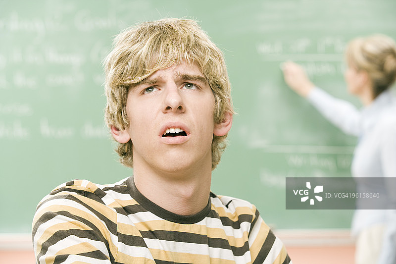 在教室里感到困惑的高中男生图片素材